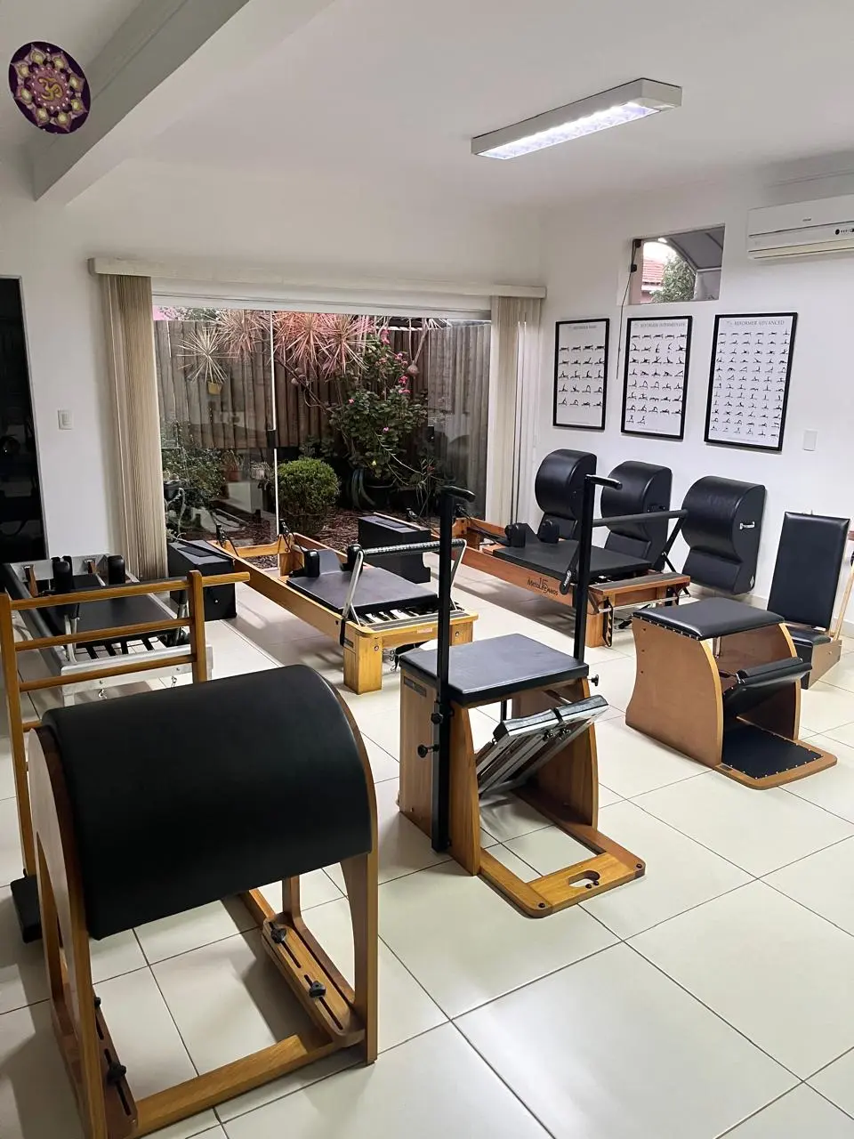 Estúdio de Pilates do Espaço Saúde com reformers, chairs e barrels diante de uma janela para o jardim